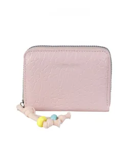 Detail of light pink mini wallet with beaded zipper pull and textured finish