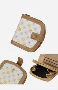 Detail view of daisy print wallet with brown leather trim and multi-slot zipper pocket