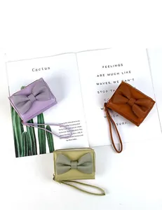 Three bow-knot PU leather wallets in purple, brown and green with wrist straps