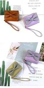 Detailed view of bow-knot PU leather wallets with pebble texture and wrist straps