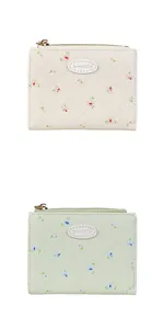 Détail de portefeuilles matelassés à fleurs avec zip doré en crème et vert clair