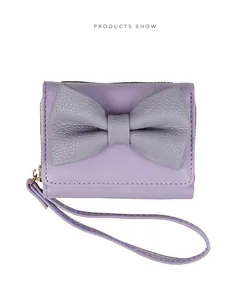 Close-up of lavender PU leather wallet with gray bow, pebble texture, and gold zipper