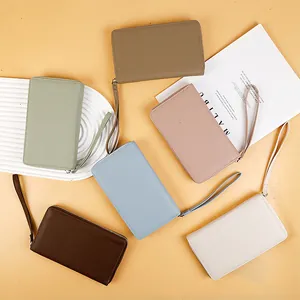 Flat lay of multi-color litchi grain long wallets with wrist straps and metal zippers