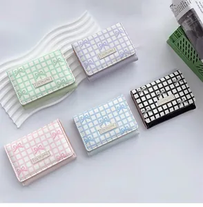 Flat lay of colorful tri-fold wallets with cute bow prints and metal nameplates