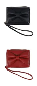 Detail of red and black PU leather wallets with bow decor and matching wrist straps