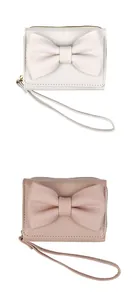 Detail view of compact bow purses in white and pink leather with metallic zippers