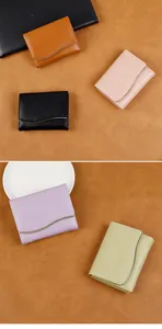 Detail of short wallets with gold curved hardware and textured lychee leather material