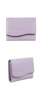 Detail view of purple leather short wallet with wave-shaped gold metal trim and embossing