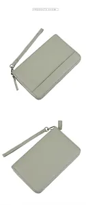 Detail showing light green litchi grain leather wallet with wrist strap and silver zipper
