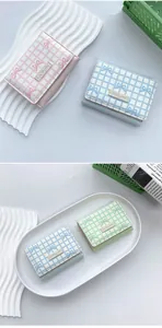 Close-up of pastel plaid trifold wallets with bow detail in pink, blue, and green