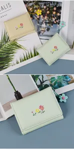 Detail of floral embroidery and flower pendant on PU leather trifold wallets