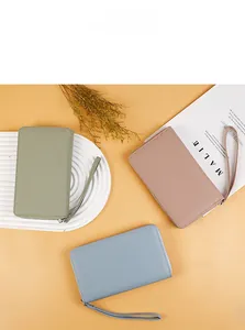 Three lychee grain leather passport wallets in green pink and blue with wristlet straps