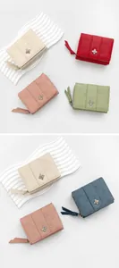 Detailed close-up of textured leather wallets in five colors with clover hardware