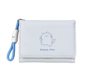 Detailed close-up of a white tri-fold wallet with cat print and blue woven wristlet strap