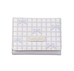 Detailed view of lavender checkered purse with bow print and Cute Girl leather patch