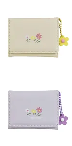 Detail view of floral print PU leather trifold wallets in beige and lavender with flower charms