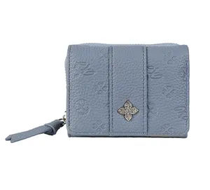 Detail view of smog blue leather wallet featuring four-leaf clover embossing and silver floral charm