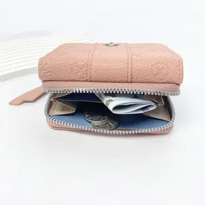 Pink pebbled leather women's tri-fold wallet with embossed clover and silver zipper