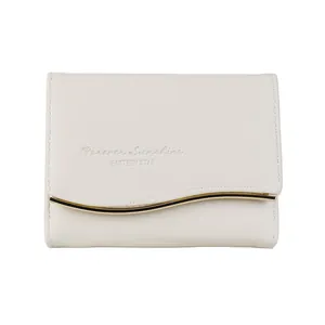 Elegant cream tri-fold wallet for women with golden wavy metal trim and chic textured finish