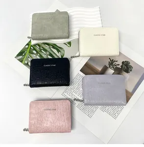 Detailed top view of five textured synthetic leather coin purses with zipper closures