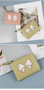 Detail of cute PU leather wallets with bowknot patches and portable wrist straps