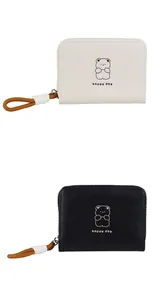 Détail de porte-monnaie ours mignon en noir et crème avec tirettes de fermeture tressées