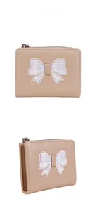 Close-up of beige PU leather wallet with a lavender plaid bow and metal zipper detail