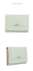 Detail of mint green tri-fold wallet with bow decoration and pink lining cards slots
