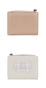 Close-up of stylish faux leather wallet with detailed bow embroidery and zipper texture
