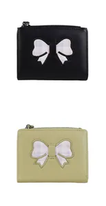 Detail of short PU leather bow wallets in black and light green with silver metal zipper