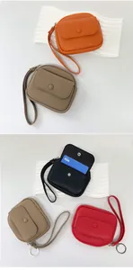 Detail view of mini litchi textured leather coin purse with wrist strap and zipper closure