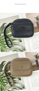 Close-up of pebble leather coin purses in black and beige with wristlet straps