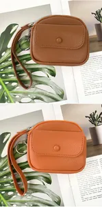 Detail of lychee textured leather coin purse with wrist strap and metal keyring