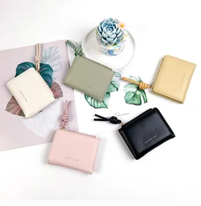 Flat lay of colorful PU leather wallets with knotted zipper pulls and classic lettering