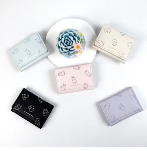 Flat lay of five mini PU leather tri-fold wallets featuring cute animal prints and soft colors