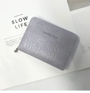 Detail of light purple coin purse with embossed stone texture and silver classic star text