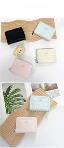 Close-up of pastel women's bow wallets with smooth metal zippers and neat stitching details