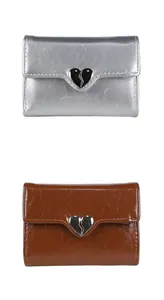 Makro-Detail von Leder-Briefbörsen mit Herz-Metallschnallen in Silber und Dunkelbraun-Optik