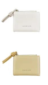 Detailed view of small leather wallets in white and khaki with leather knot pullers
