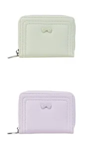 Detailed view of pastel bow wallets in light green and purple with smooth zippers