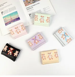 Flat lay showing six pastel PU leather trifold wallets with cute bear patterns