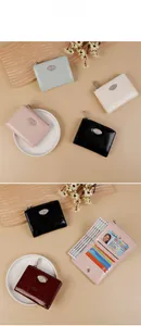 Close-up of pleated patent leather wallets with swan logo and multiple card slots