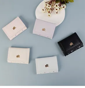 Vue à plat de portefeuilles pliants colorés pour femmes avec fermoir fleur en métal