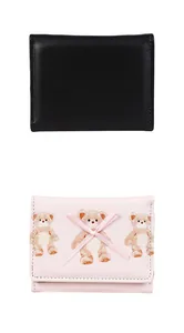 Close-up of black matte and pink cartoon bear short tri-fold wallets with bow detail
