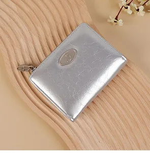 Detailed view of silver crinkle textured wallet with oval metal logo and zipper closure