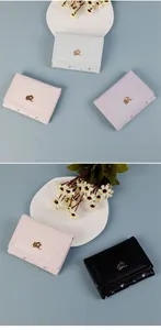 Détail de petits portefeuilles à trois volets en quatre couleurs avec fermoir fleur dorée