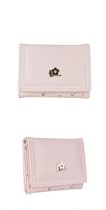 Détail du portefeuille rose à trois volets avec logo fleur dorée et motif floral élégant
