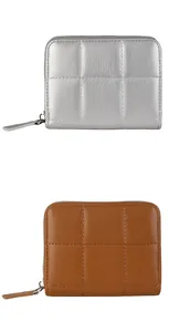 Detail view of quilted PU leather mini wallets in brown and silver with zip closure