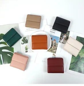 Vista piatta di portafogli colorati in pelle a grana litchi con design minimalista