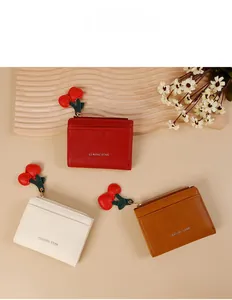 Vue à plat de petits portefeuilles bicolores rouge, blanc et marron avec fermetures cerise